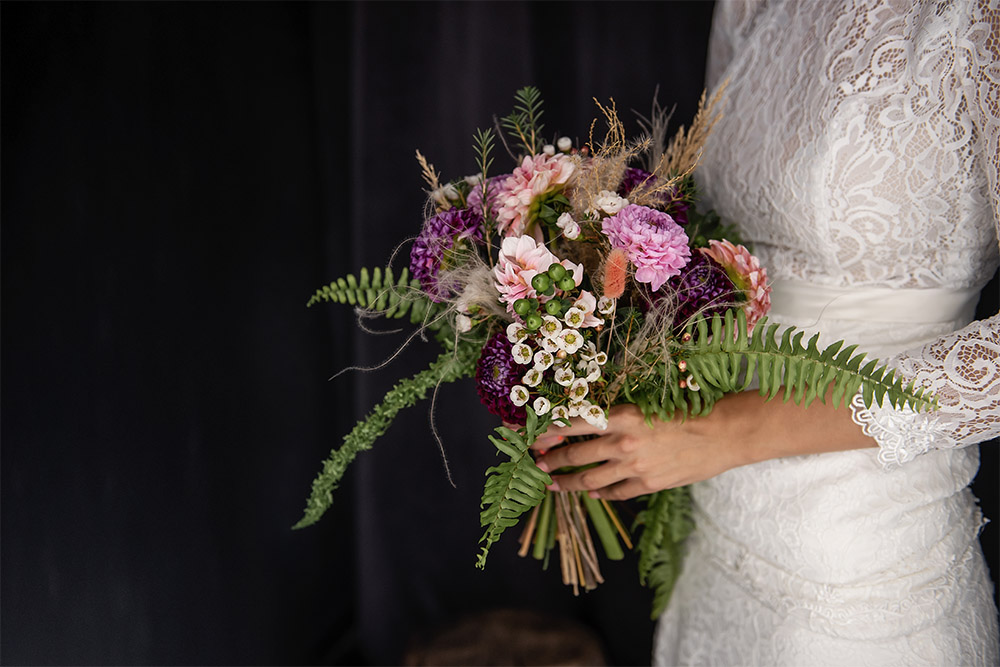 bride holding a fern bouquet